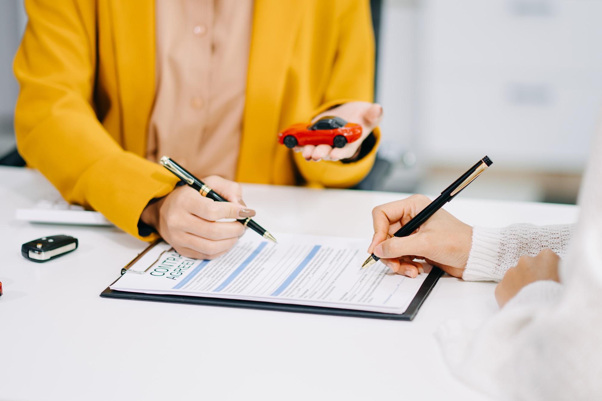 Asian people car salesman or sales manager offers to sell a car and explains of signing a car